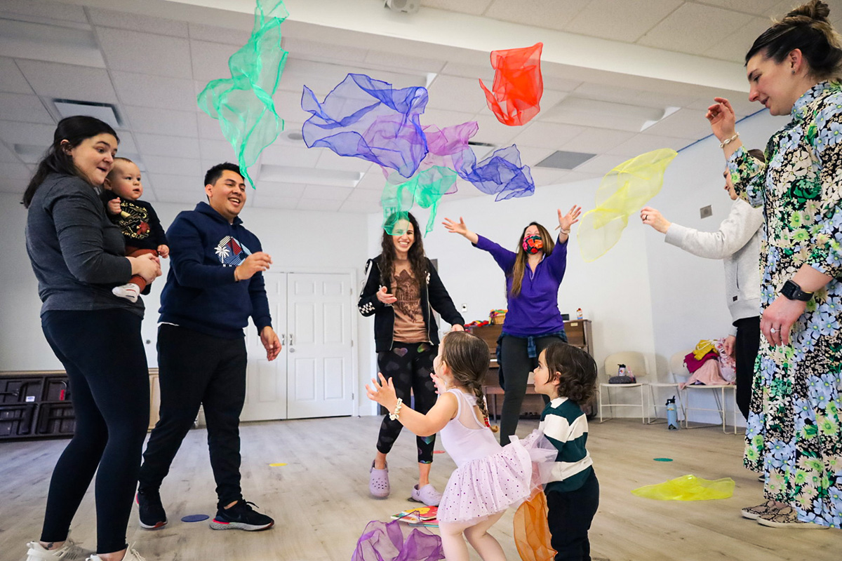 Fabric floats in the air and children watch it fall during a class