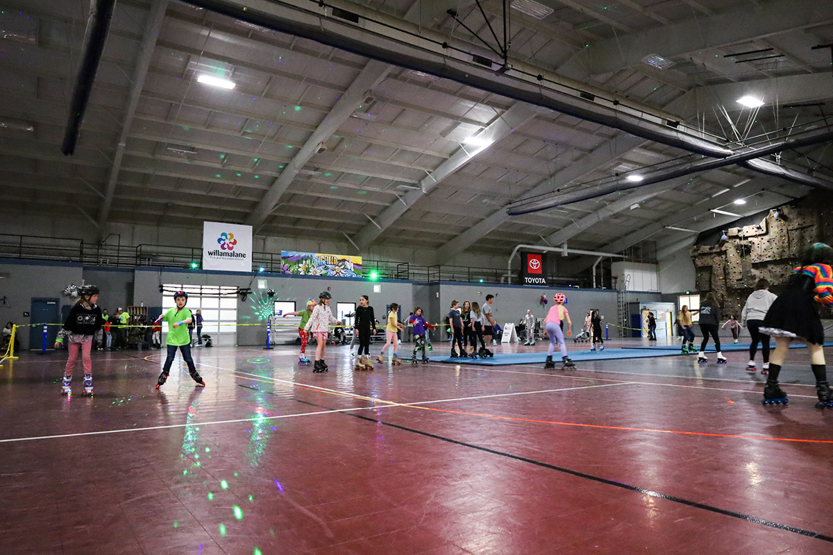 Community members skate at indoor roller skate party