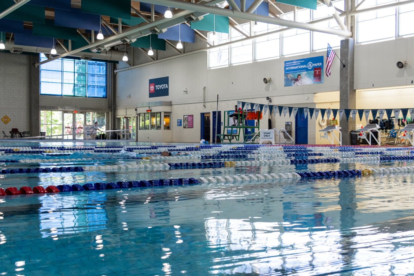 Light from the windows reflects on rippled pool water.