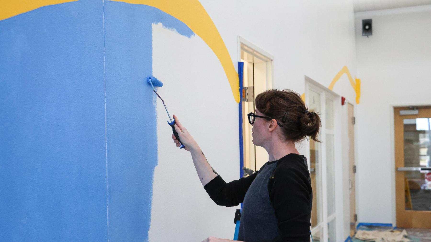 Artist paints an indoor mural