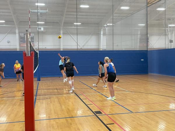 volleyball team mid-play with one player gearing up to hit the ball