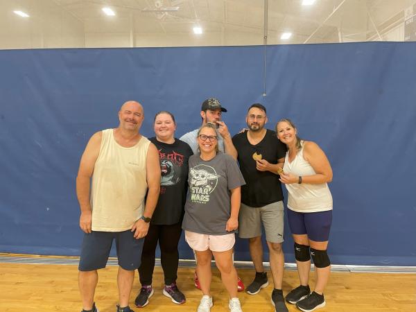 six volleyball players posing in the gym