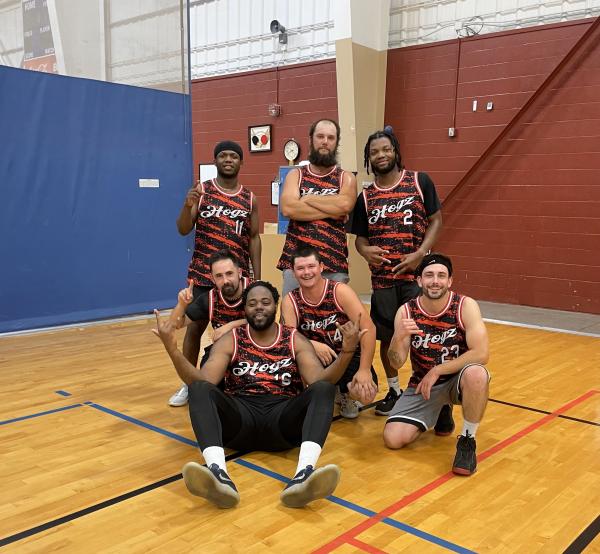 seven men pose in the gym, some serious and some smiling