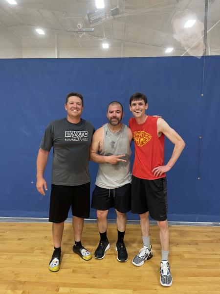 Three men smile in the gym