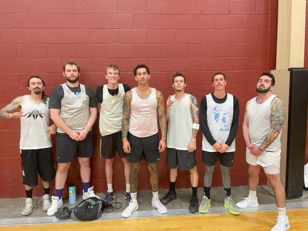 Seven men pose in the gym