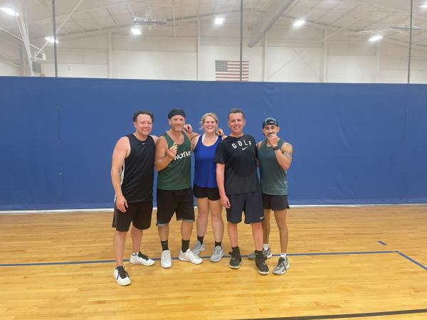 five people posing on the volleyball courts