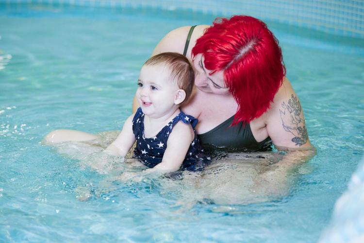 Parent and child play together in pool
