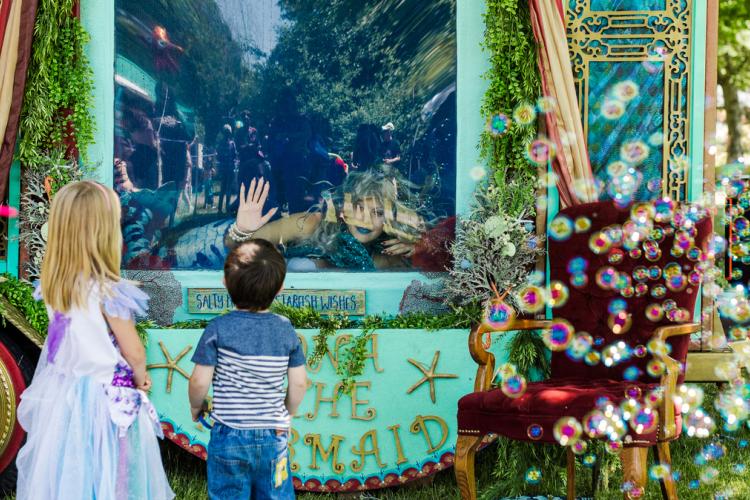 A mermaid entertains children at outdoor event