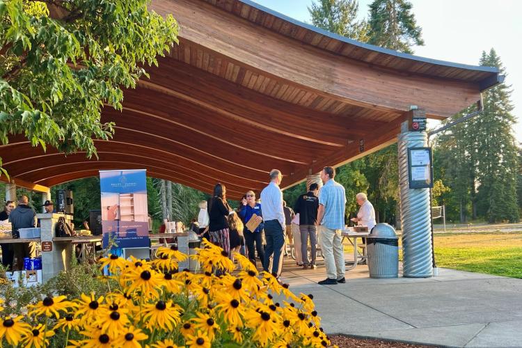 A local business event takes place in outdoor shelters on a sunny morning