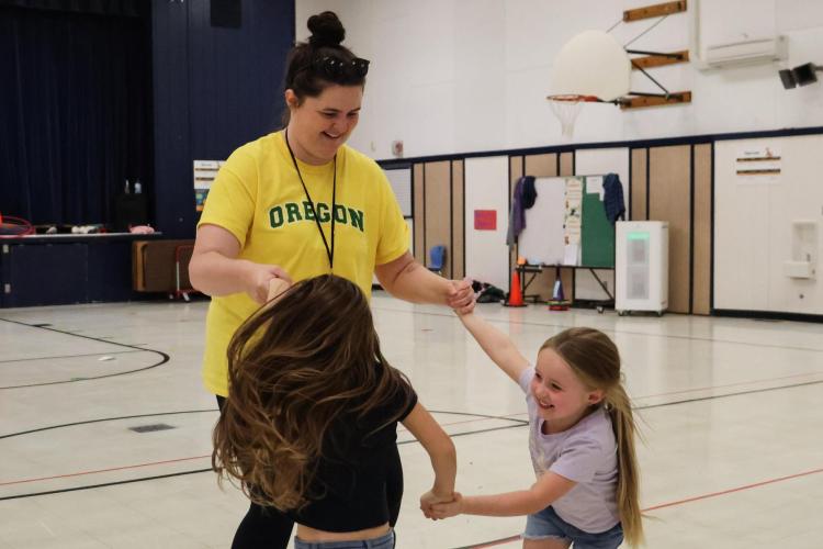 Willamalane staff member plays with students in gym