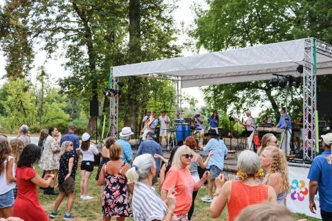 A crowd stands in front of an outdoor stage.