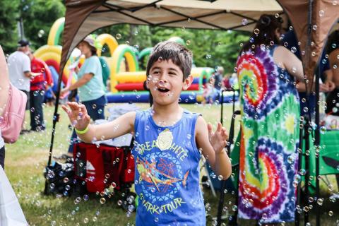 Child plays with bubbles at outdoor children's event