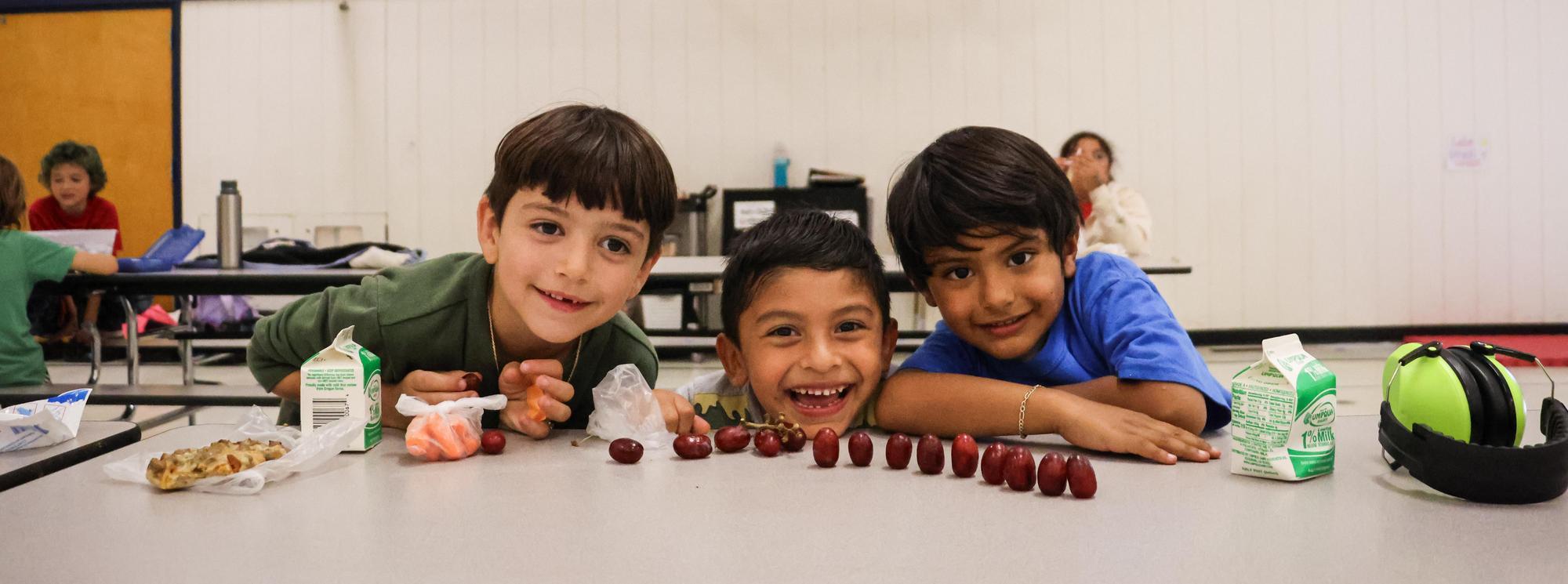 Three kids enjoy snack at Springfield Elementary School