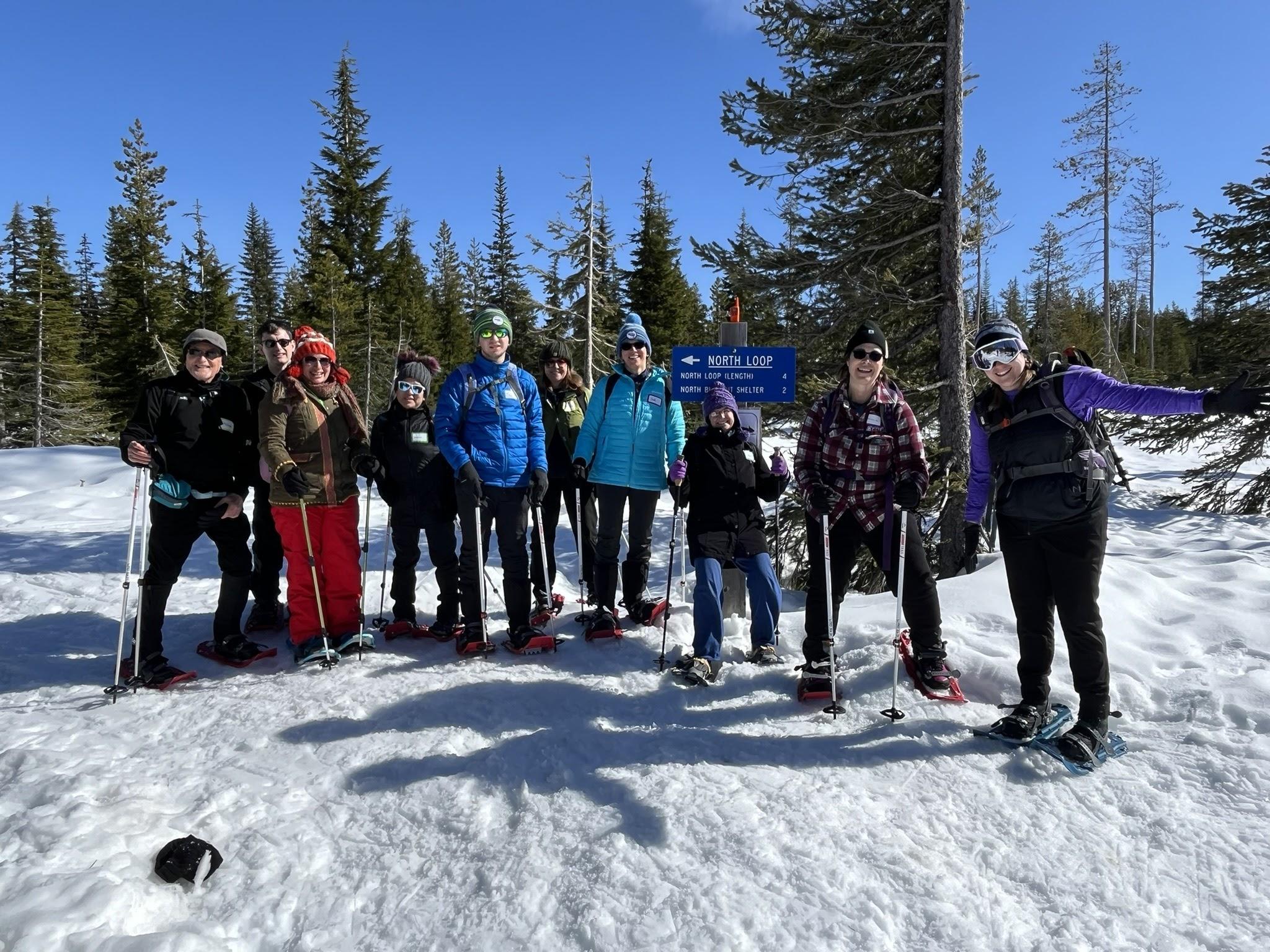 A group of people stand on top of a snowy landscape.