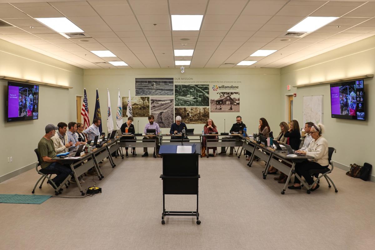 A group of people sit at tables discussing policy.