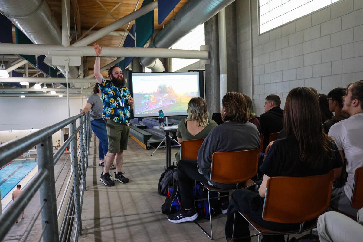 An adult stands on an elevated deck next to a pool.
