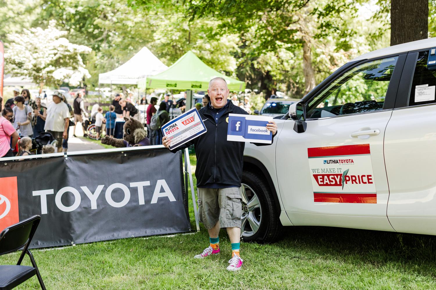 Toyota representative poses at Children's Celebration with branded materials