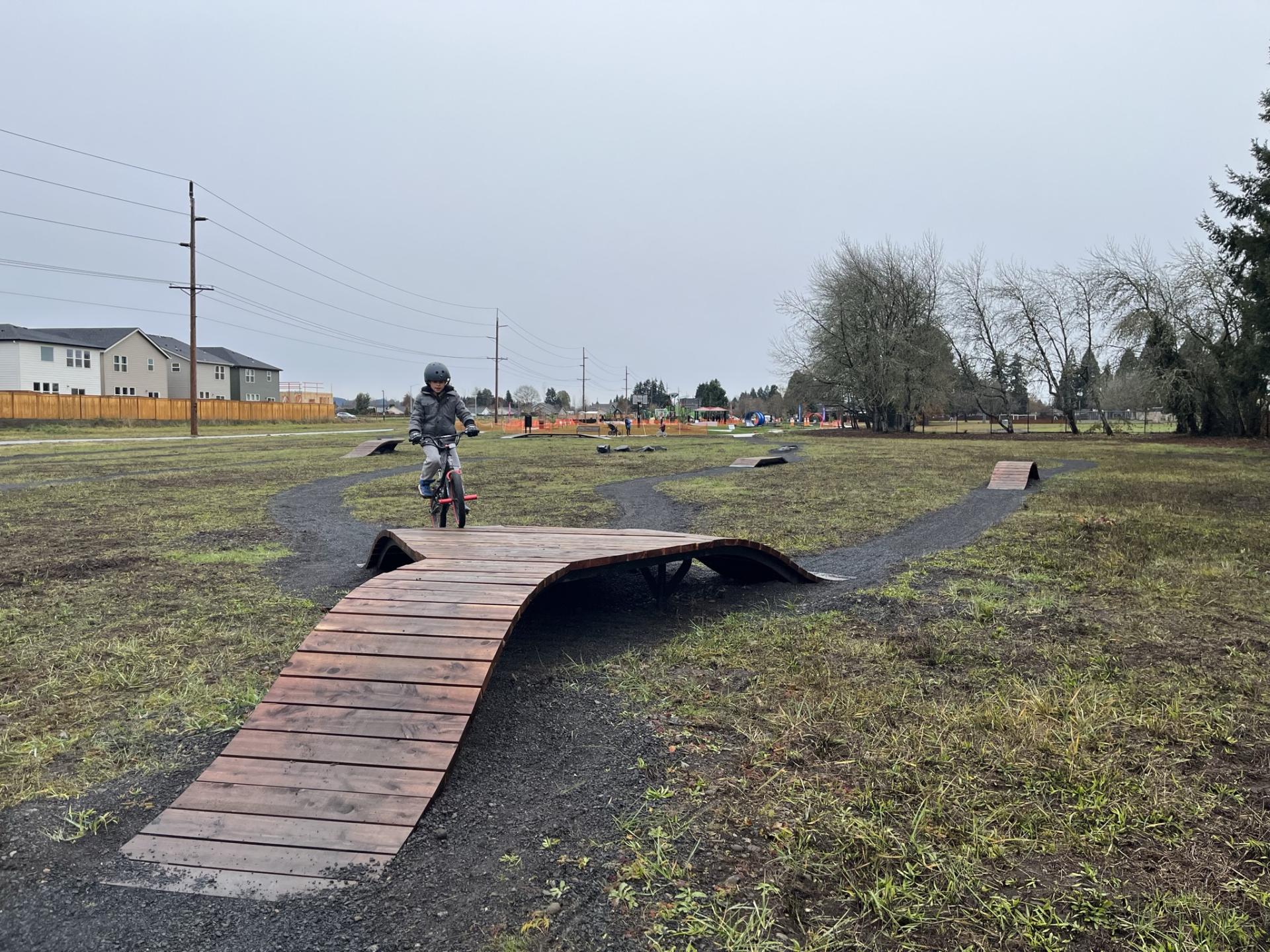 Child rides bike on outdoor course
