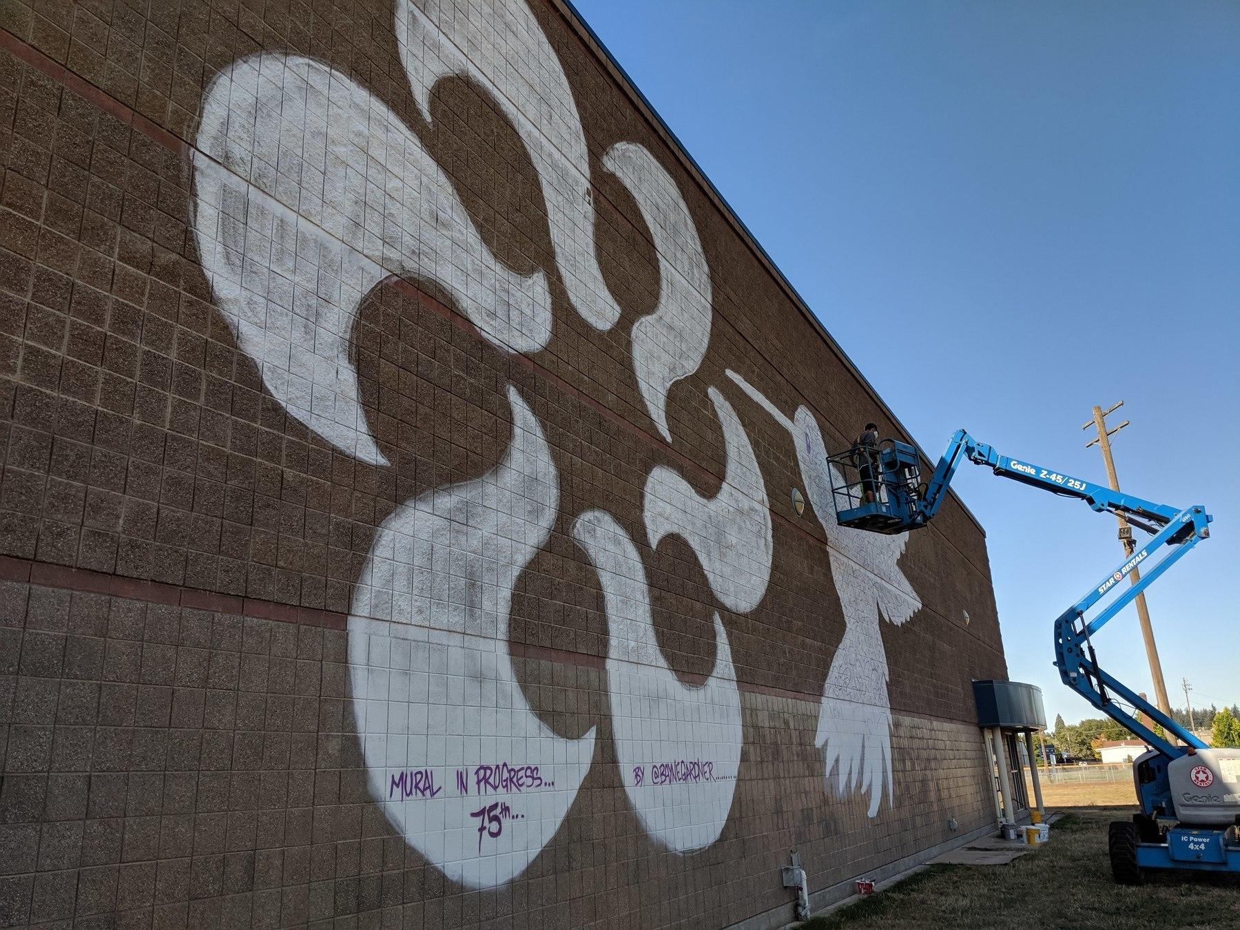 A lift helps artist reach large mural