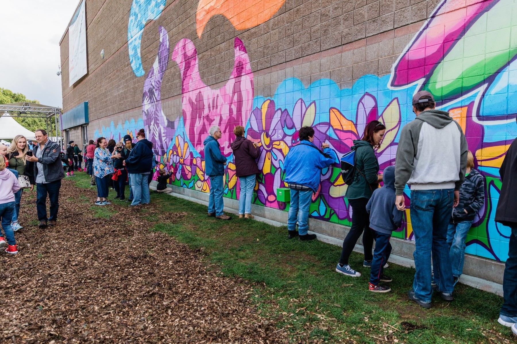 Community members sign a large mural