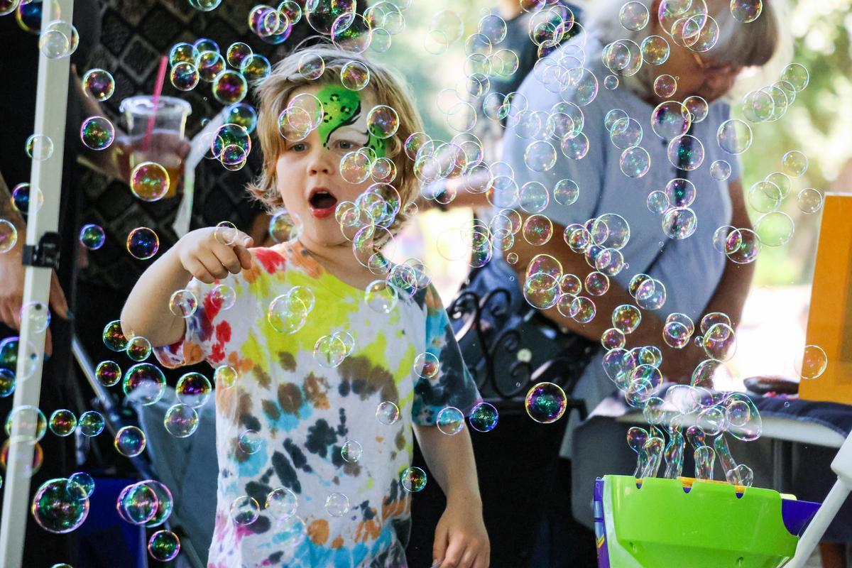 Child pops bubbles at Children's Celebration