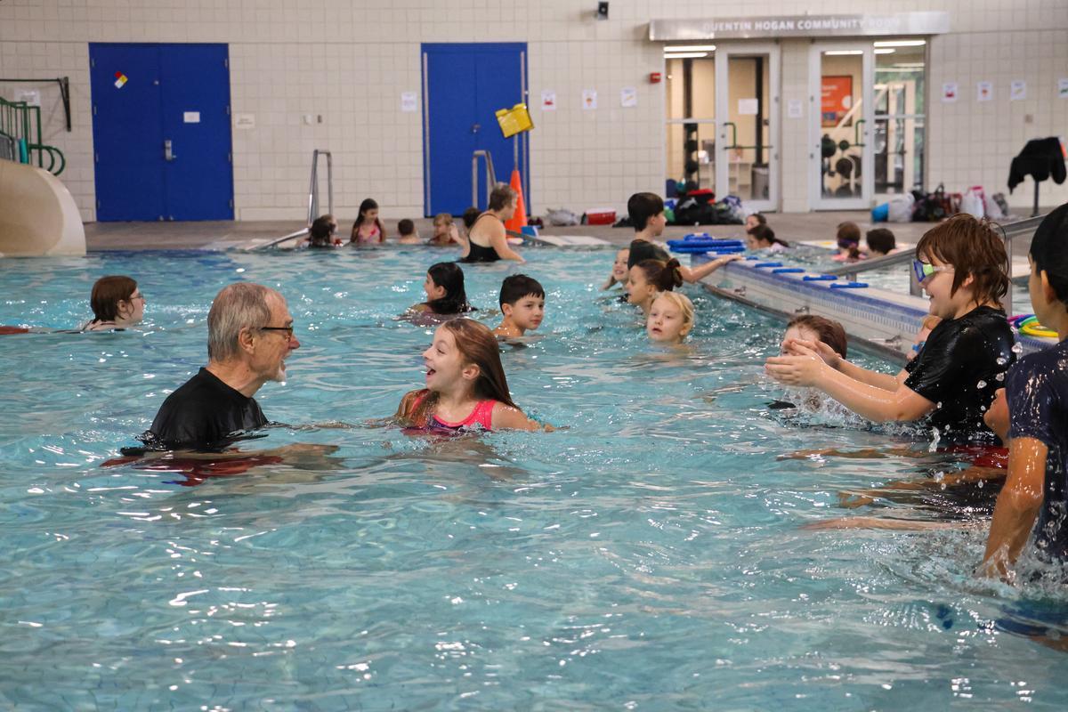 Swim instructor talks with children in the water during lessons
