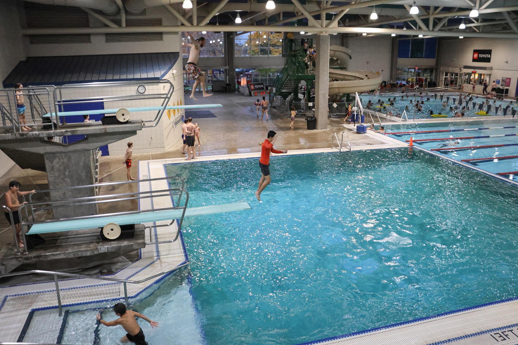 People dive off two high diving boards 