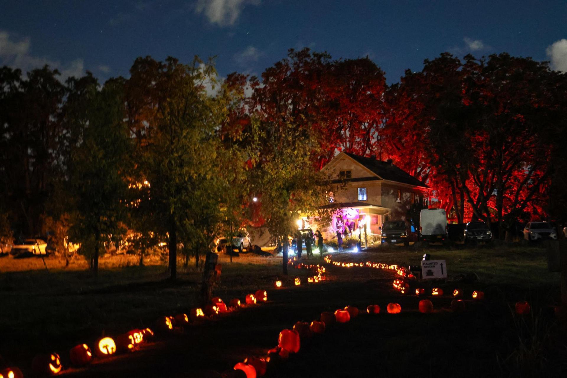 Tomseth House lit up at night with a path lit with glowing pumpkins