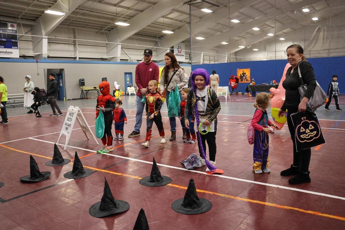 Children stand in front of witches hats arranged in a patten on the floor.