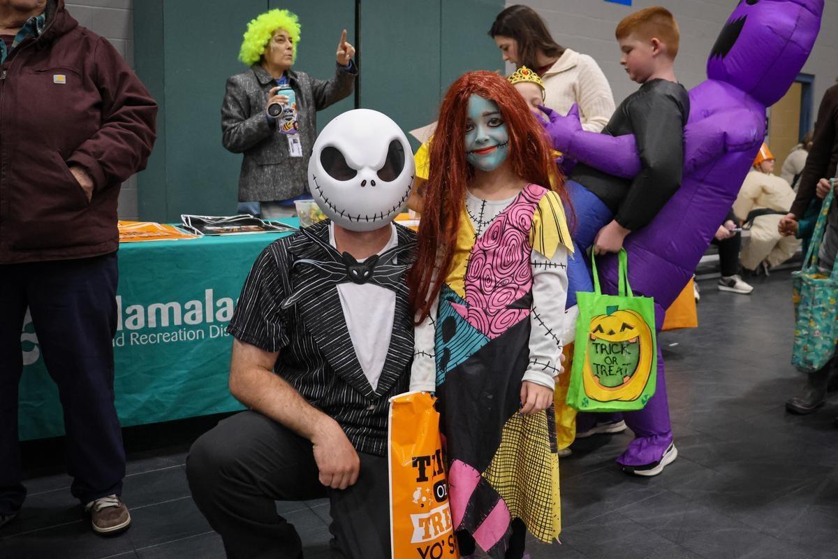 Two people in costume pose for a photo together, one crouched down and the other standing.