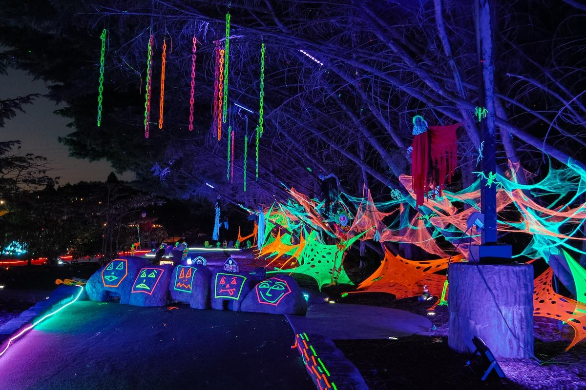 A mini golf course at night with glow in the dark decorations.