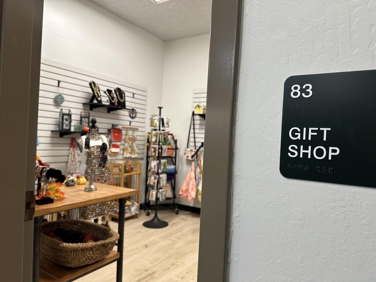 A gift shop sign in front of a store with handmade goods.