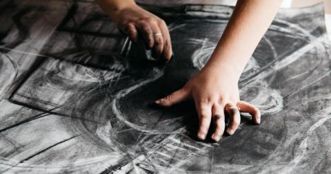 hands creating charcoal artwork